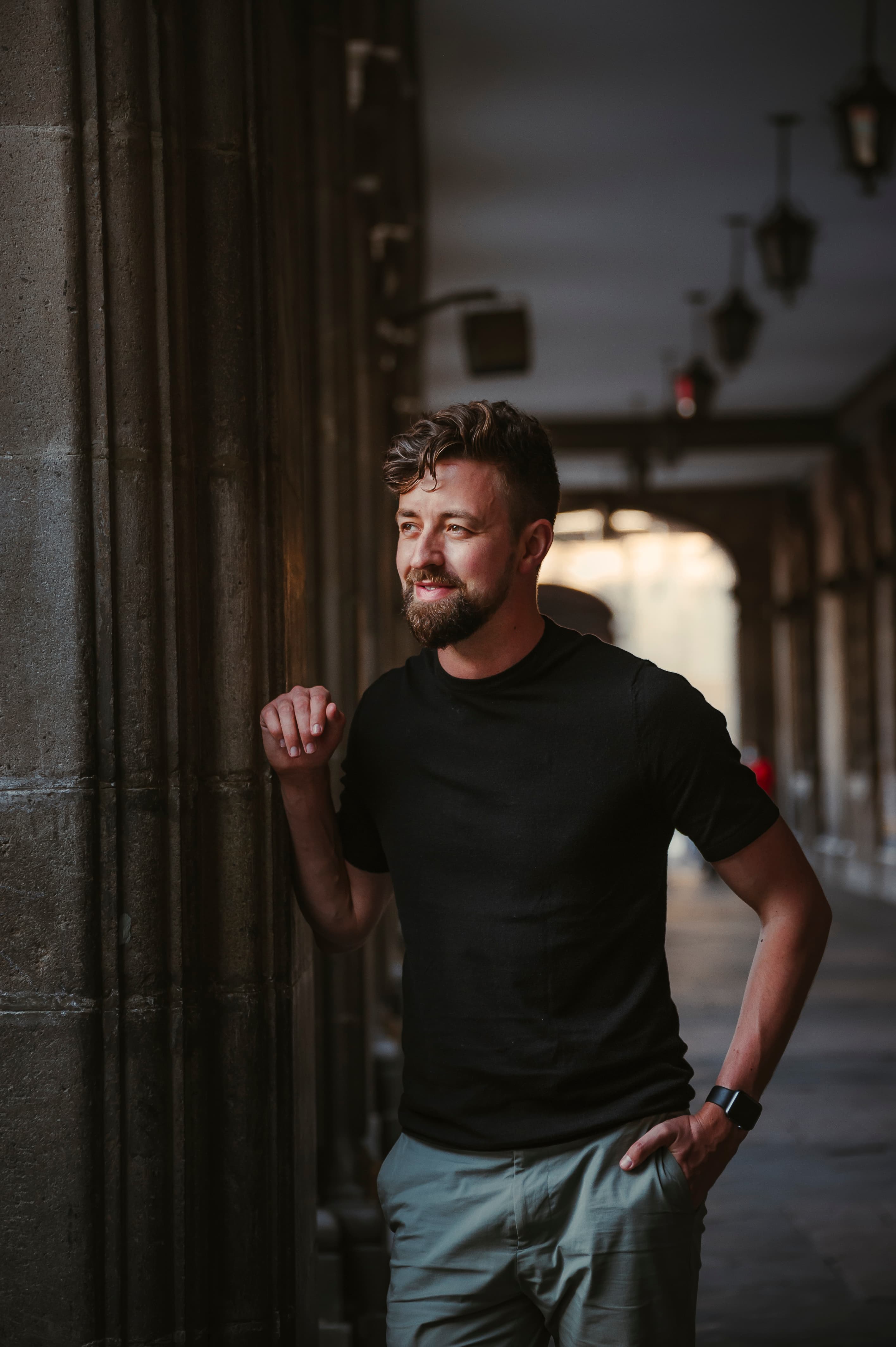 Michael leaning against an old wall in a black t-shirt